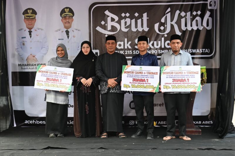 Bupati Aceh Besar, H Muharram Idris dan Ketua TP PKK Aceh Besar, Hj Rita Mayasari foto bersama peraih Hadiah Umrah Juara 1 MTQ Pidie Jaya di Halaman Dekranasda Aceh Besar, Gampong Gani, Kecamatan Ingin Jaya, Aceh Besar, Selasa (10/03/2026).