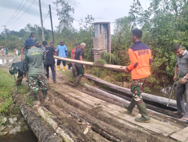 Prajurit TNI bersama warga bersinergi membangun jembatan. Foto: Pendam IM
