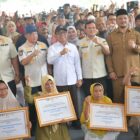 Menko PMK Pratikno bersama Mendagri Tito Karnavian dan Wakil Gubernur Aceh Fadlullah berfoto bersama warga penerima bantuan usai penyerahan simbolis bantuan perbaikan rumah rusak akibat bencana hidrometeorologi di Kabupaten Aceh Tamiang, Selasa (21/04/2026). Foto: (Humas Aceh).