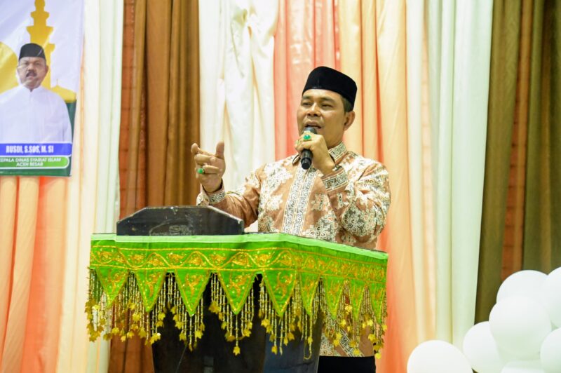 Bupati Aceh Besar, H Muharram Idris memyampaikan sambutan pada acara peusijuk dan pelepasan Jamaah Umrah Para Juara MTQ dan MKQ di Gedung Dekranasda, Gampong Gani, Kecamatan Ingin Jaya, Aceh Besar, Sabtu (27/06/2026).