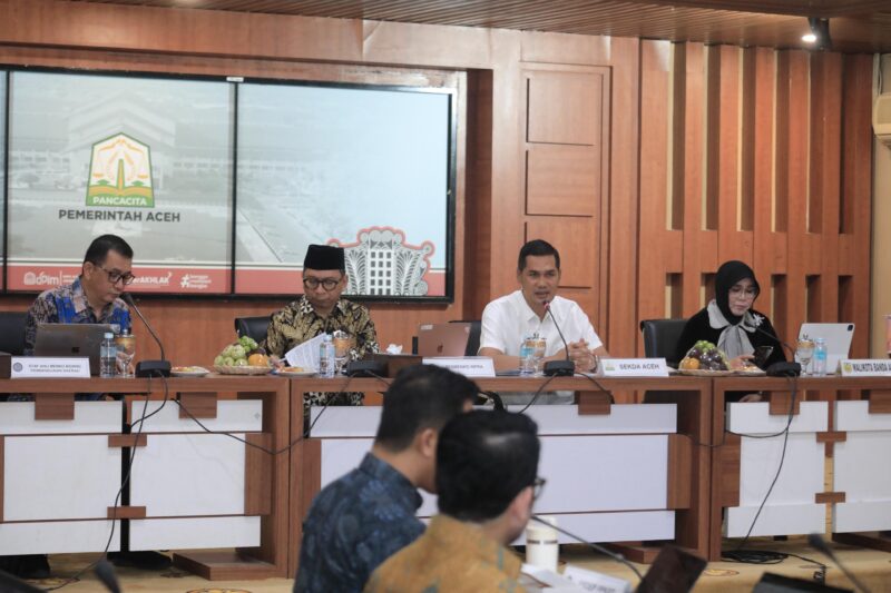 Sekretaris Daerah Aceh, M. Nasir Syamaun, menyampaikan paparan mengenai perkembangan penanganan bencana hidrometeorologi Aceh saat Rapat Koordinasi Percepatan Rehabilitasi dan Rekonstruksi Pascabencana Sumatera di Gedung Serbaguna Setda Aceh, Jumat (24/7/2026). Foto: (Humas Aceh).