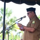 Sekda Aceh Besar Bahrul Jamil saat membacakan amanat Menteri Pemberdayaan Perempuan dan Perlindungan Anak Republik Indonesia, sebagai Inspektur Upacara Peringatan Hari Anak Nasional ke 42 & HARGANAS KE-33, di Halaman Kantor Bupati, Kota Jantho, Senin (27/07/2026).