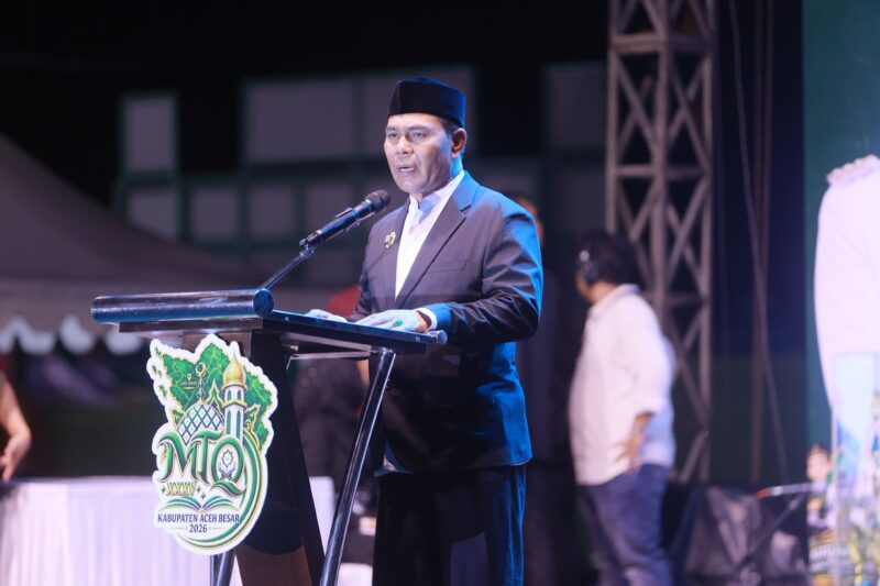 Bupati Aceh Besar H. Muharram Idris memakai baju hakim kepada Ketua LPTQ Aceh Besar, Farhan AP pada pembukaan MTQ XXXV di Lapangan Bung Cala, Kecamatan Kuta Baro, Aceh Besar, Sabtu (24/10/2026) malam.